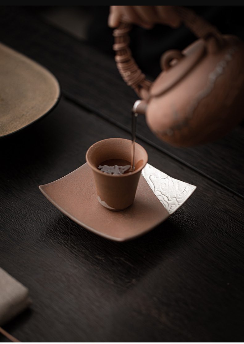 空寂老岩泥瓦片杯墊，南山居手工紫砂茶壺與茶杯，壺身雕刻細緻，茶湯注入杯中，展現優雅禪意品茗氛圍。