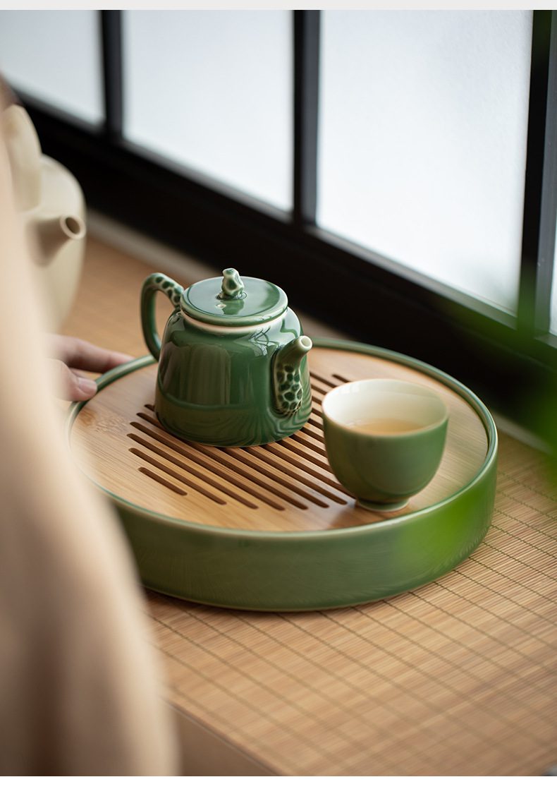 青璃釉枯石手執茶壺，南山居青瓷禪意茶具套組，釉色如玉細膩，搭配質感楠竹茶盤，展現清雅簡約的品茗空間。