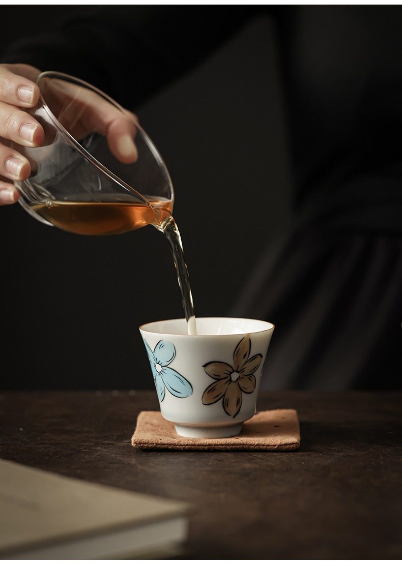 漫花品茗杯，南山居手工彩繪花卉瓷杯，細膩描繪清雅花影，晶瑩茶湯注入其中，盡顯雅致茶道氛圍。
