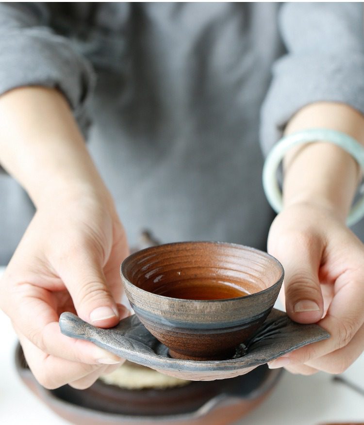 古早燒粗陶品茗杯，南山居粗陶茶杯，手工拉胚紋理細膩，搭配仿生樹葉造型茶托，呈現質樸禪意。