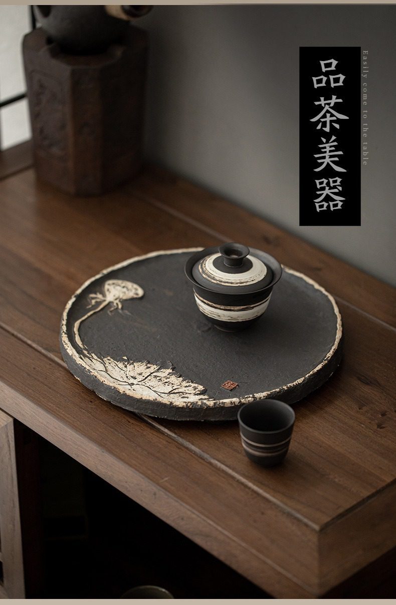 侘寂風蓮香圓茶盤,南山居禪意手工粗陶茶盤與黑白條紋蓋碗,盤身雕刻寫意蓮花,質感質樸厚重,適合文人品茗空間。