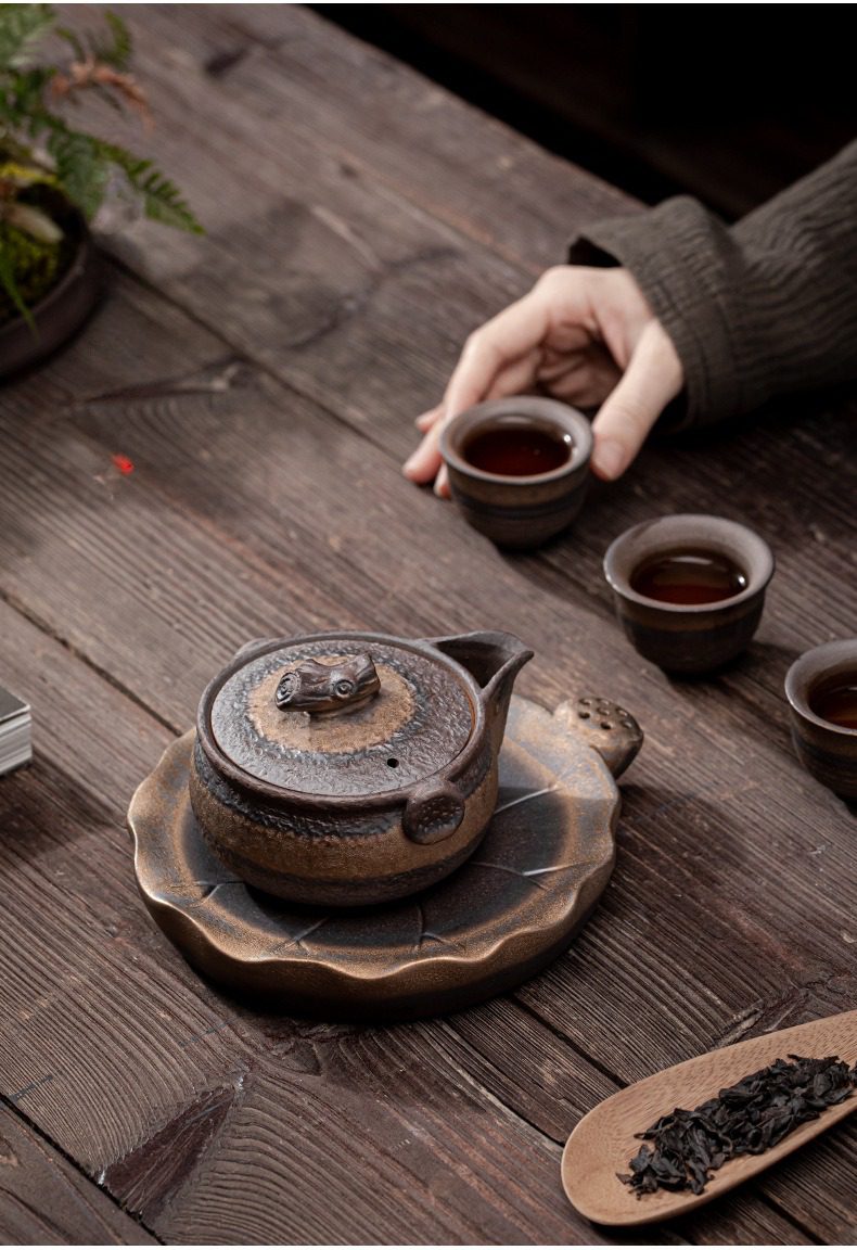 古早燒木蓋鎏金手抓壺，南山居粗陶柴燒茶具組，古樸厚實的壺身設計，搭配仿生蓮葉茶盤，展現質樸禪意美學。