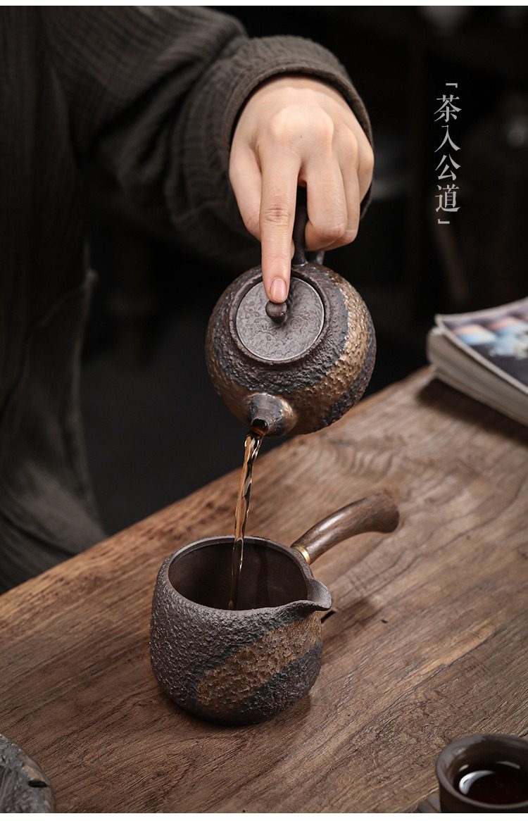 古早燒黑檀側把公道杯，南山居粗陶手把壺與茶海，壺身呈現獨特岩礦肌理，金屬木質手柄設計，茶湯傾注間展現古樸禪意風格。