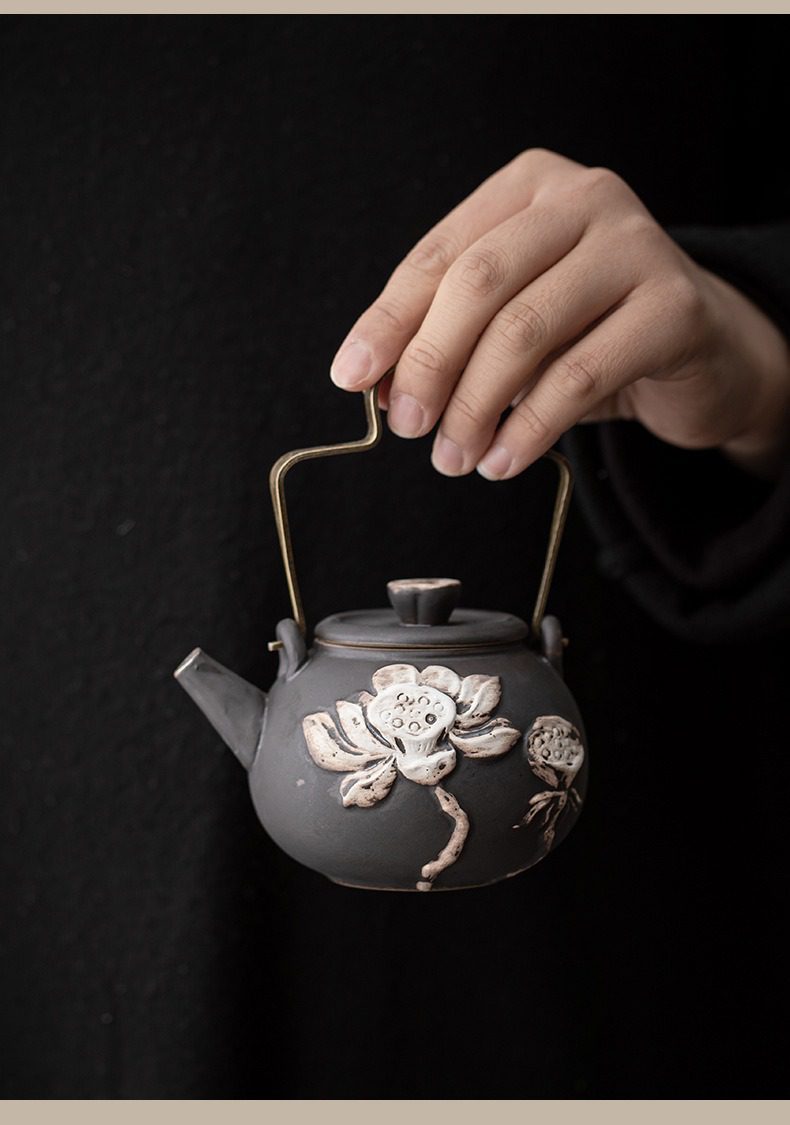 侘寂風蓮花圓韻提樑壺，南山居手工黑陶提樑壺，壺身雕刻立體荷花紋飾，精緻古樸，展現禪意茶具美學。