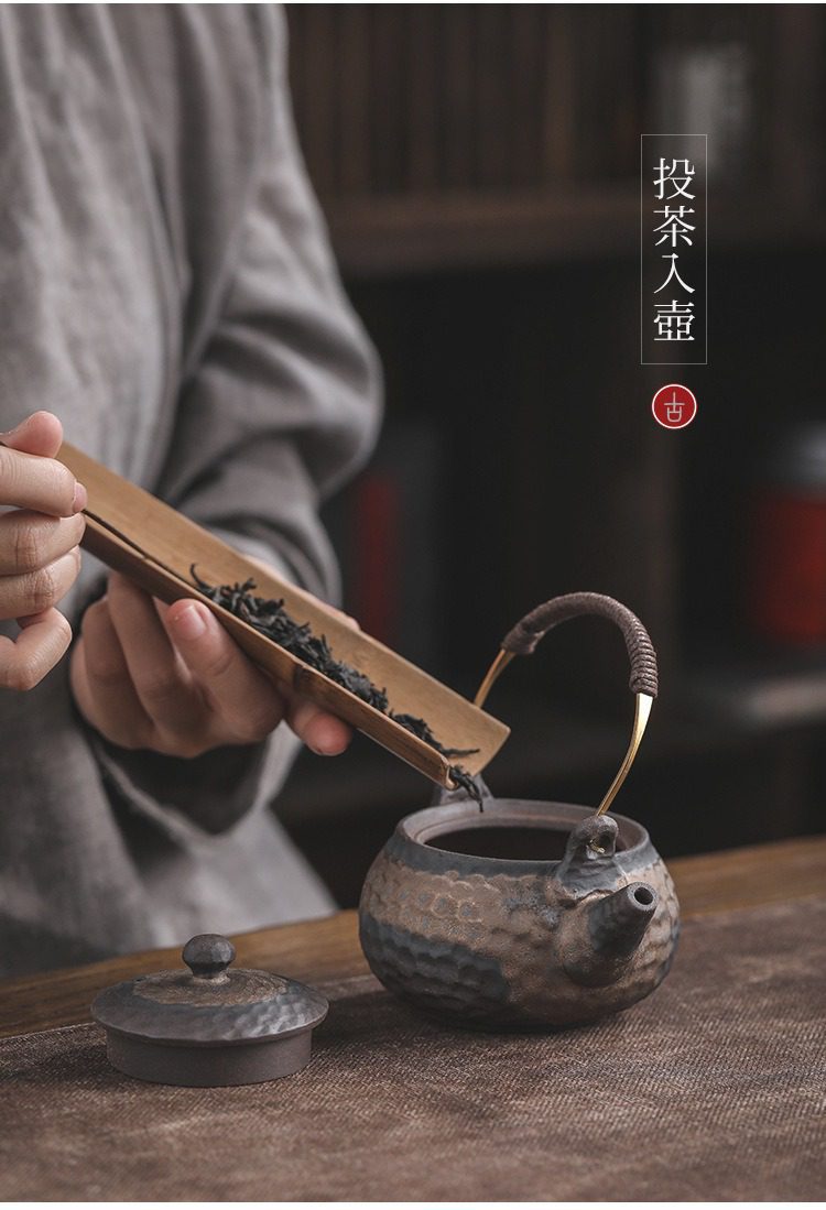 古早燒鎏金溫茶爐,南山居手工粗陶提梁壺,呈現古樸鎚紋肌理,正以竹製茶則進行投茶儀式,展現深厚茶道文化之美。