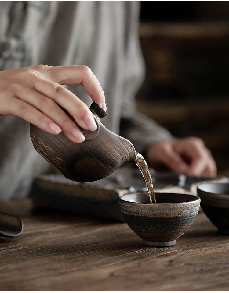 古早燒荷韻手抓壺，南山居手工粗陶茶壺，壺身呈現古樸窯變肌理，與同系列陶杯相映成趣，展現質樸茶道美學。