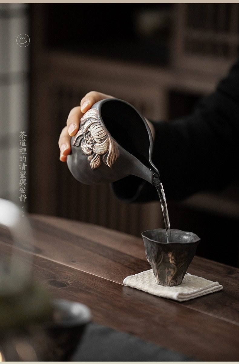 侘寂風盛蓮公道杯，南山居手工黑陶茶海公道杯，壺身雕刻立體蓮花紋飾，出水流暢，展現禪意茶道美學。