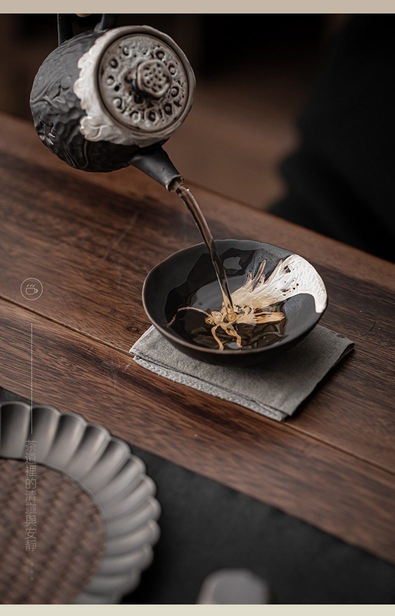 侘寂風祥龍祥雲品茗杯，南山居禪意手作黑陶茶壺與魚趣品茗杯，茶湯傾注杯中，展現出靈動的立體魚兒美學。