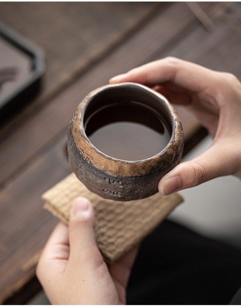 古早燒觀自在主人杯，南山居粗陶手作茶杯，杯身刻有禪意文字，金屬質感釉面展現古樸粗獷美學。