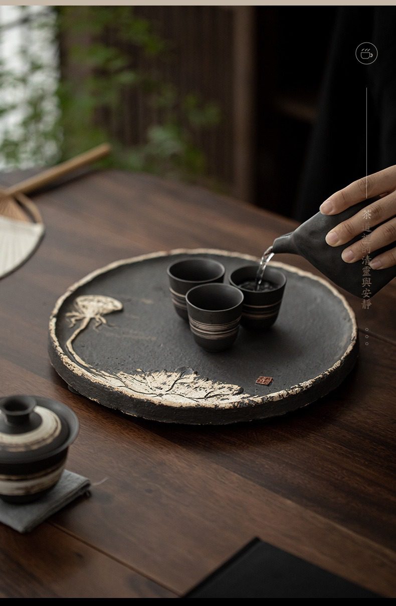 侘寂風蓮香圓茶盤,南山居手工禪意黑陶茶盤,盤面刻有精美蓮葉浮雕,搭配粗陶茶杯,展現古樸雅致的品茗空間。