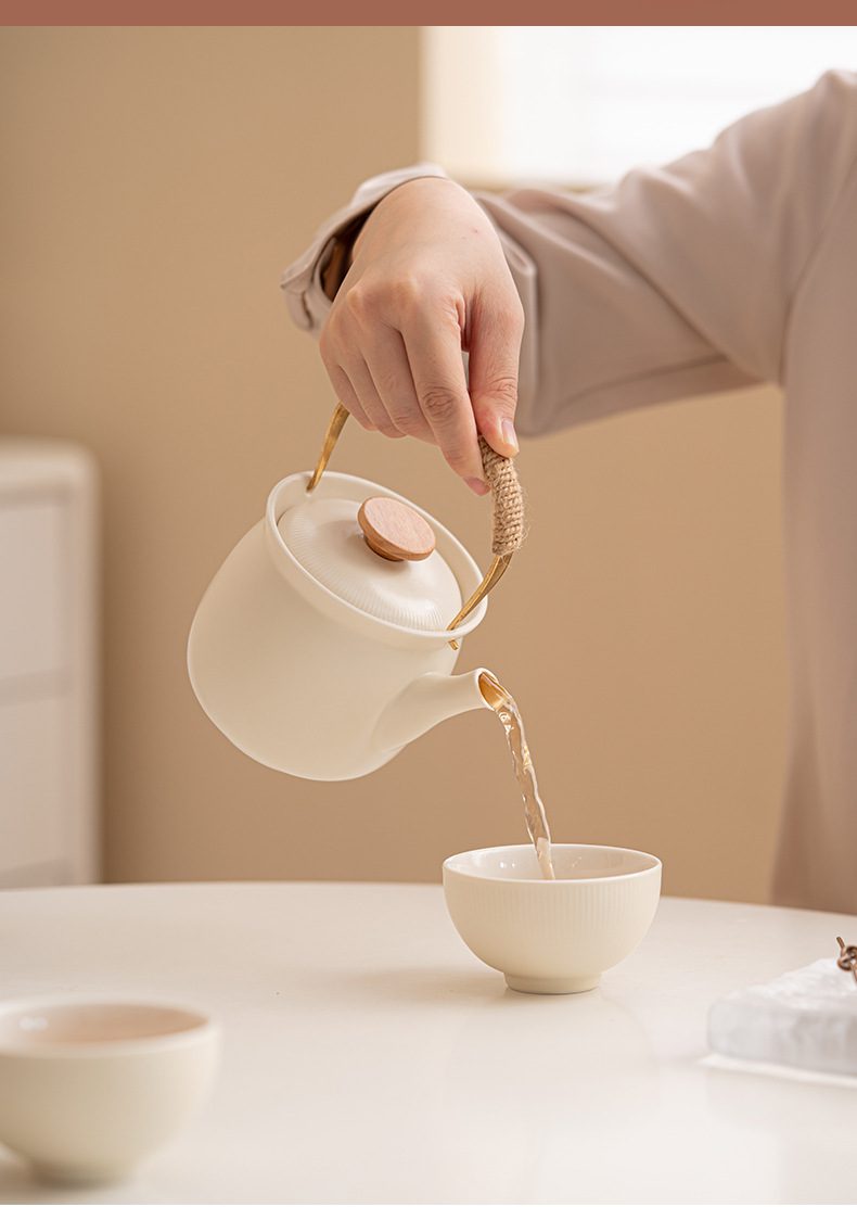 奶油風品茗杯，南山居日式簡約白瓷提樑壺，搭配溫潤木質壺鈕與細膩線條，展現靜謐禪意的倒茶美學。