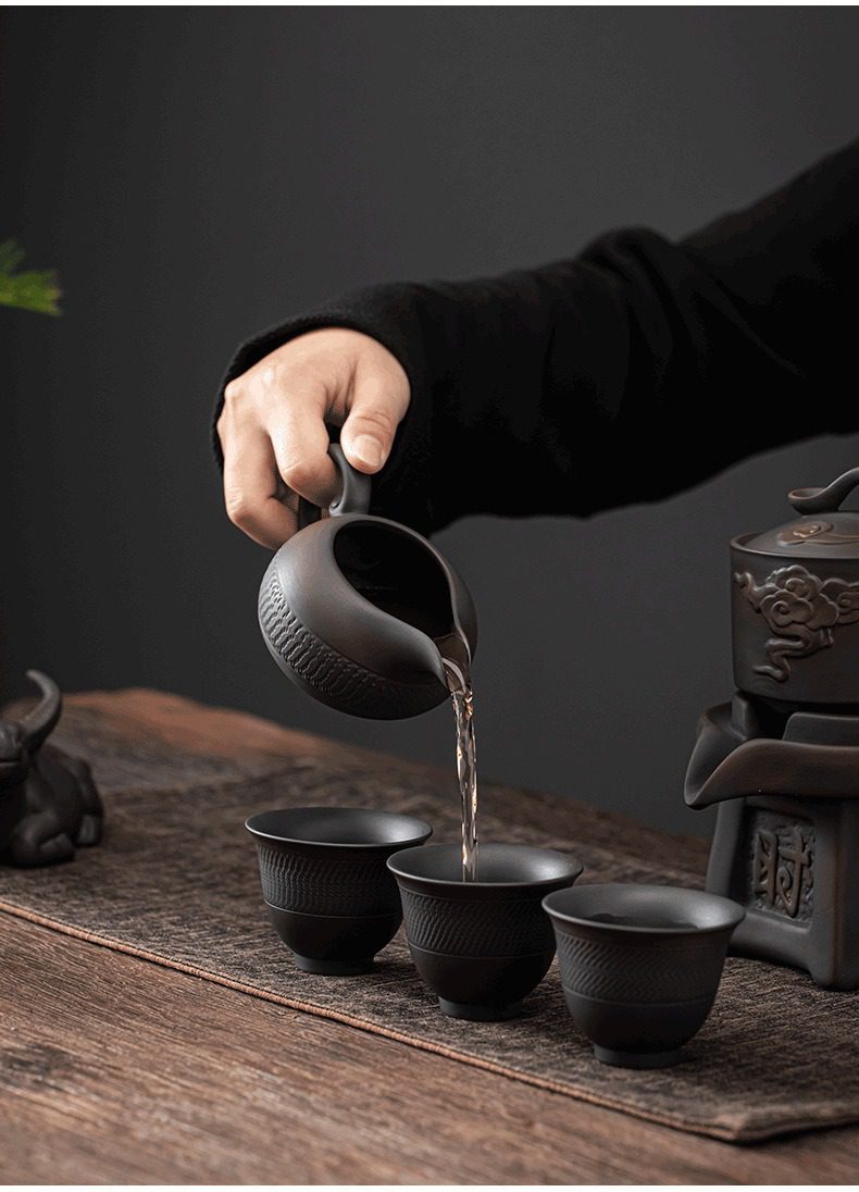紫陶清溪自動茶具組，南山居黑陶公道杯，杯身雕刻精細紋理，注茶流暢，展現古樸雅緻的茶道美學。