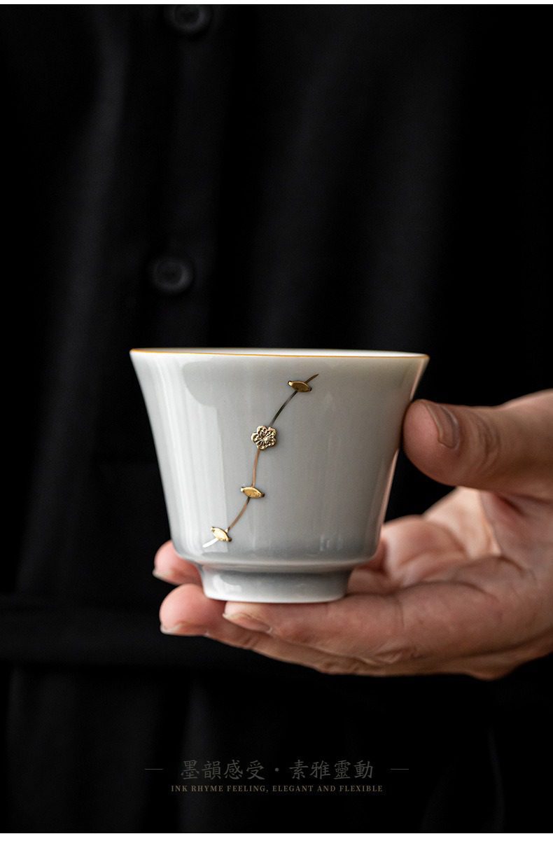 冰灰釉鋦釘品茗杯，南山居手工金絲梅花釉下彩茶杯，杯身潔白透亮，描金梅花圖案優雅細膩，呈現精緻茶道美學。
