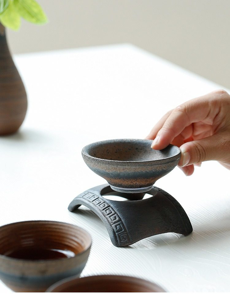 古早燒粗陶拱橋過濾茶漏，南山居粗陶茶杯與精緻杯托，外觀呈現古樸滄桑質感，杯口厚實好握，適合品茗與茶席陳設。