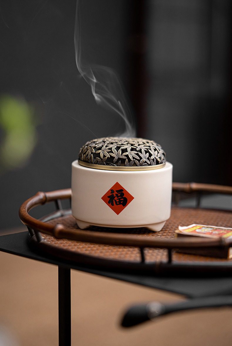草木灰盤香爐，南山居福字陶瓷香爐，配備精緻金屬縷空爐蓋，裊裊輕煙散發禪意，是茶席空間的優雅陳設。