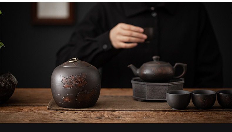 紫陶清溪茶葉罐，南山居黑泥刻繪蓮花茶葉罐，手工雕琢蓮紋細緻優雅，展現禪意茶桌美學。