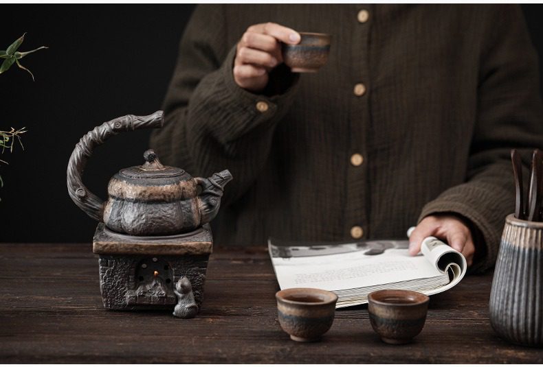 古早燒鎏金南瓜茶壺，南山居復古粗陶側把燒水壺與炭火爐，壺身造型古樸自然，爐火微光營造出沉靜的日式禪意茶席氛圍。