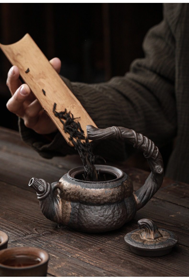 古早燒鎏金南瓜茶壺，南山居手工柴燒紫砂壺，粗獷岩石質感設計，搭配竹製茶則投入茶葉，展現原始質樸的品茗藝術。