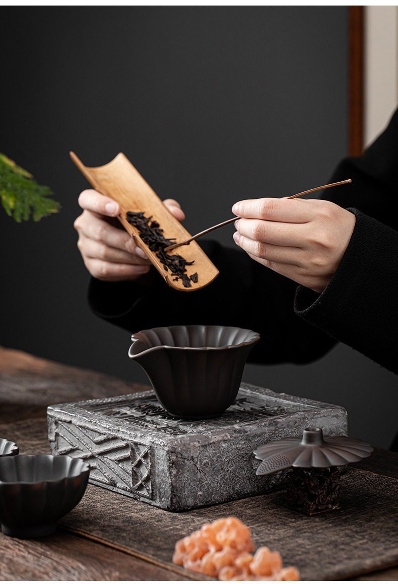 紫陶清溪花瓣手抓壺，南山居手工製作黑陶蓮花茶海，搭配竹製茶則與茶針，展現沉穩內斂的東方茶道美學。