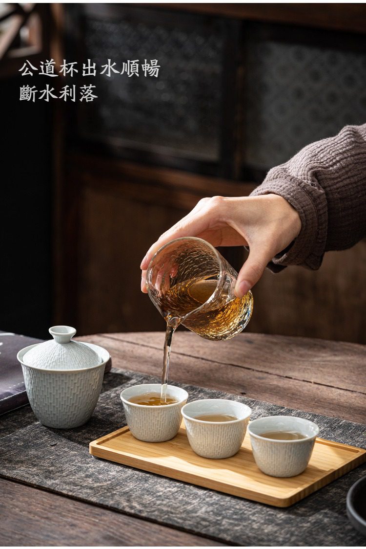 影青瓷溫馨快客杯，南山居手工冰裂紋陶瓷茶具組，茶人正持玻璃公道杯將茶湯均勻注入細膩雅緻的冰裂釉茶杯中，展現流暢倒茶工藝。