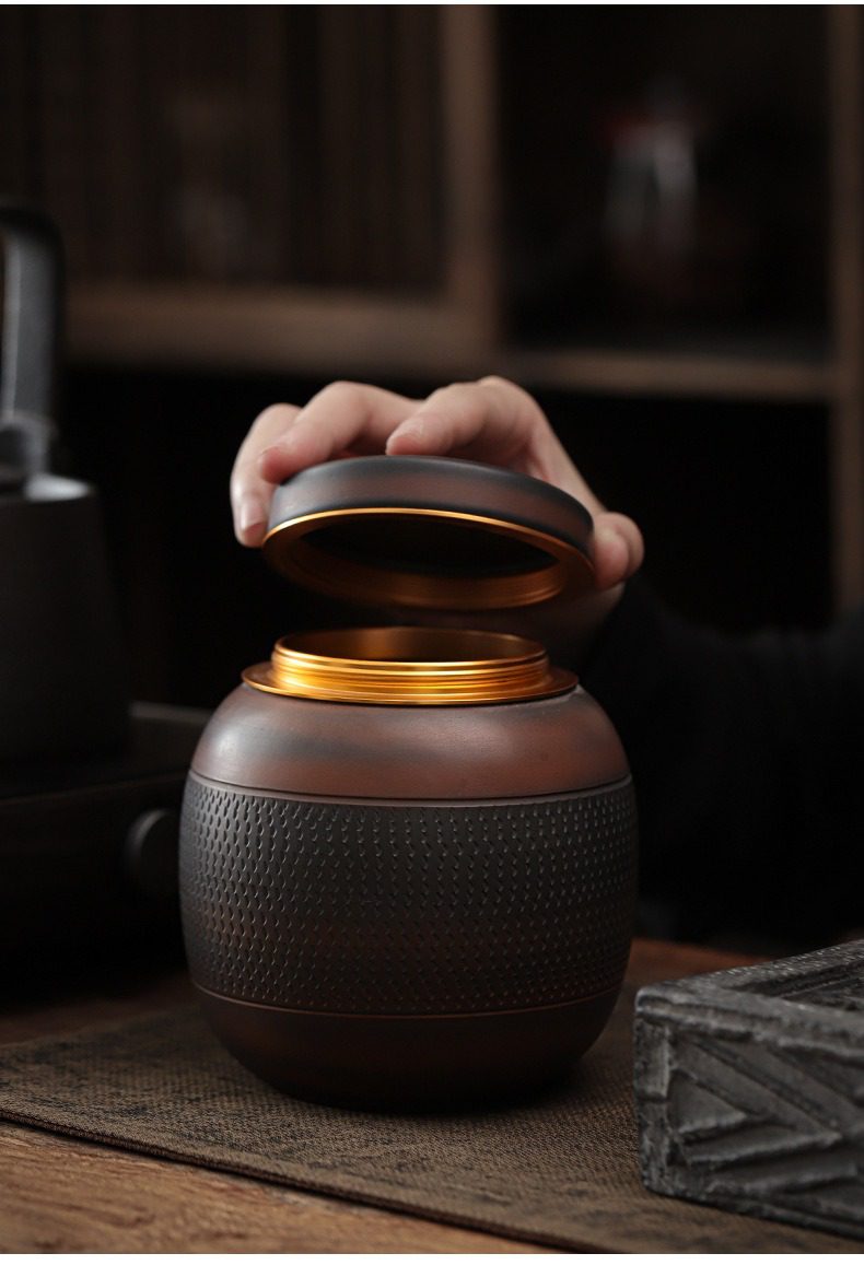 紫陶清溪圓筒茶葉罐，南山居黑陶金屬蓋茶葉罐，細膩浮雕紋理搭配金色內蓋，展現低調奢華的禪意茶具設計。