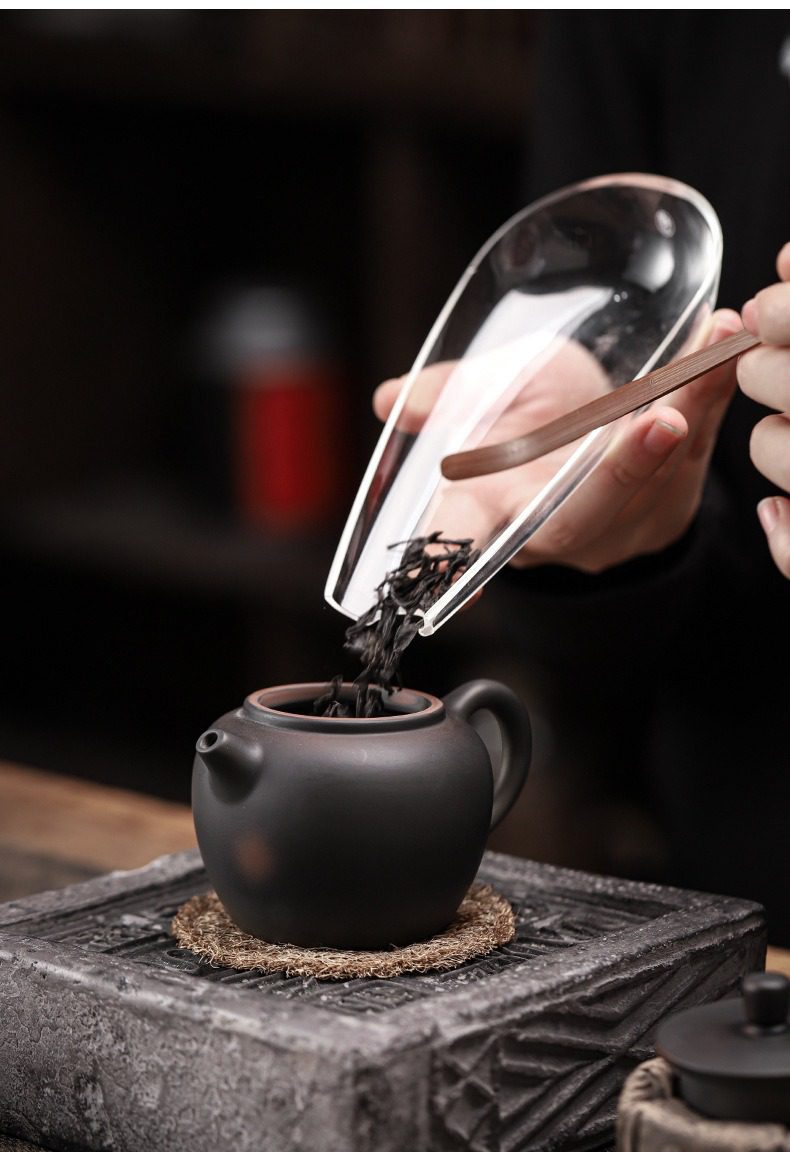 紫陶清溪聽雲茶壺，南山居手工紫砂壺與透明玻璃茶荷，優雅茶葉撥入壺中，質感細膩且充滿禪意。
