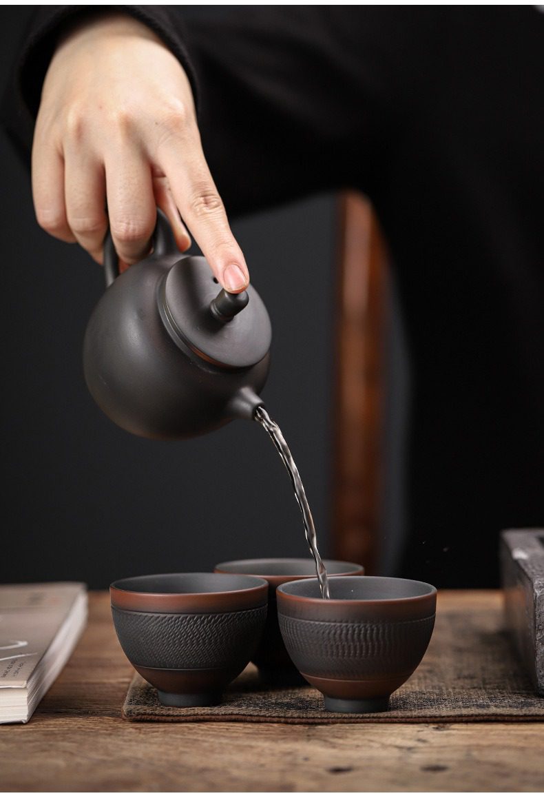 紫陶清溪聽雲茶壺，南山居手工紫砂壺，壺身呈現內斂黑紫砂質感，正示範流暢注茶，搭配精緻刻紋茶杯，展現傳統工藝美學。