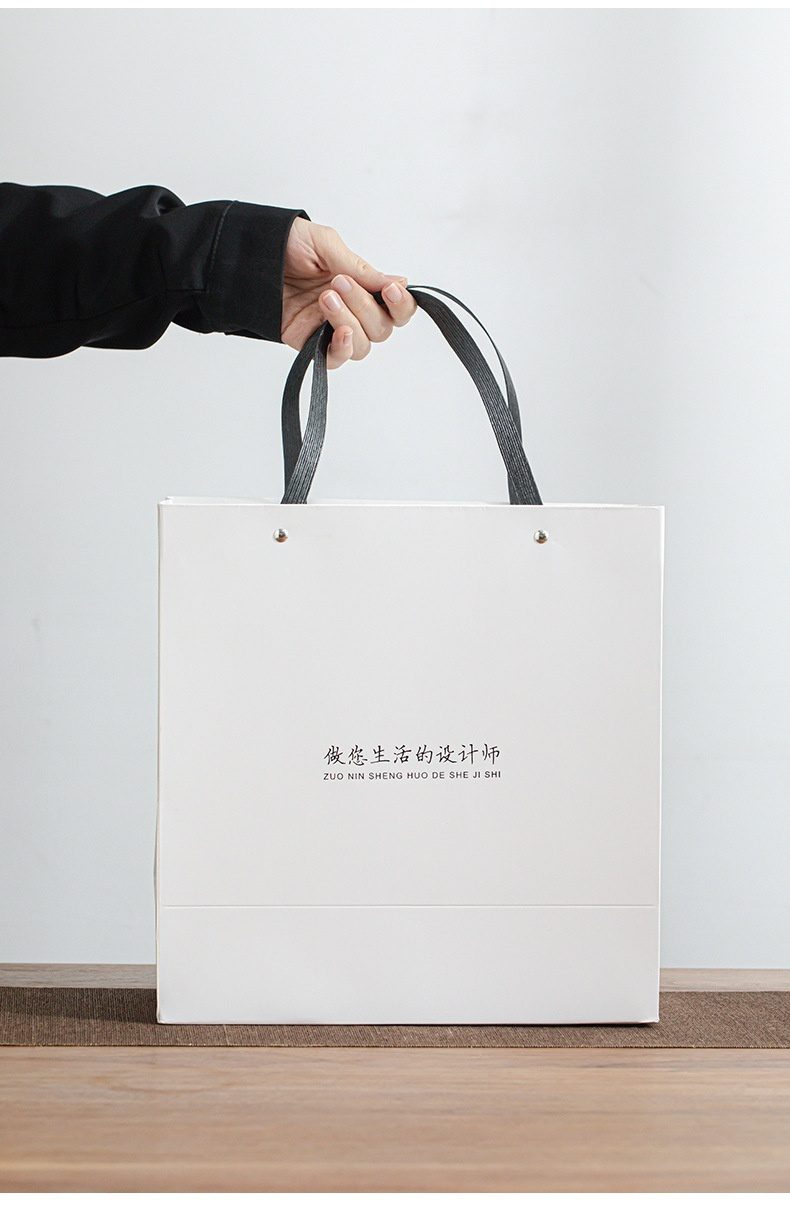 雲悅羊脂玉白瓷茶具套組，南山居品牌定制手提袋，簡約白色設計，印有品牌標語「做您生活的設計師」，適合贈送茶具茶葉。
