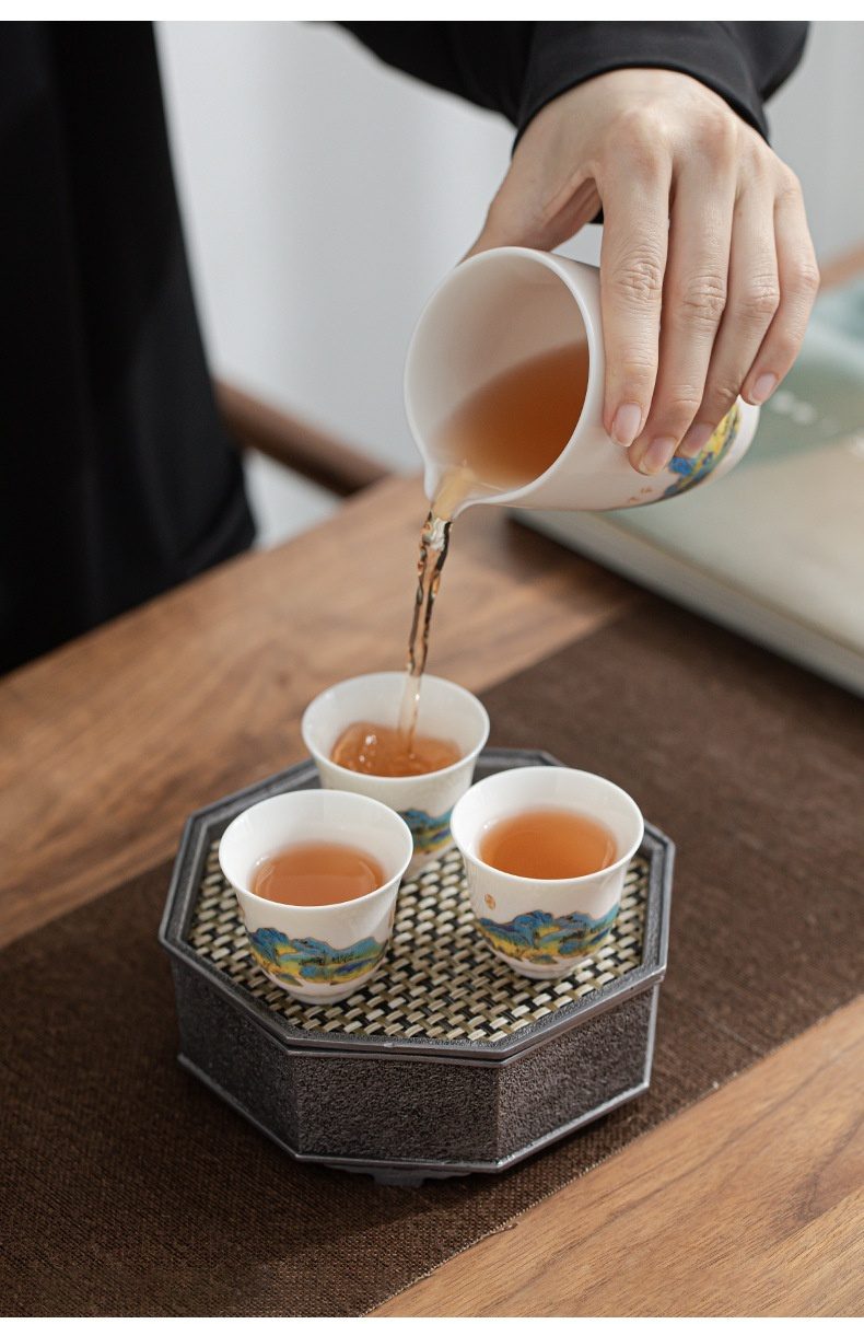 雲悅羊脂玉白瓷茶具套組，南山居手繪山水陶瓷公道杯與茶杯組，正優雅地將茶湯注入，展現茶道美學。
