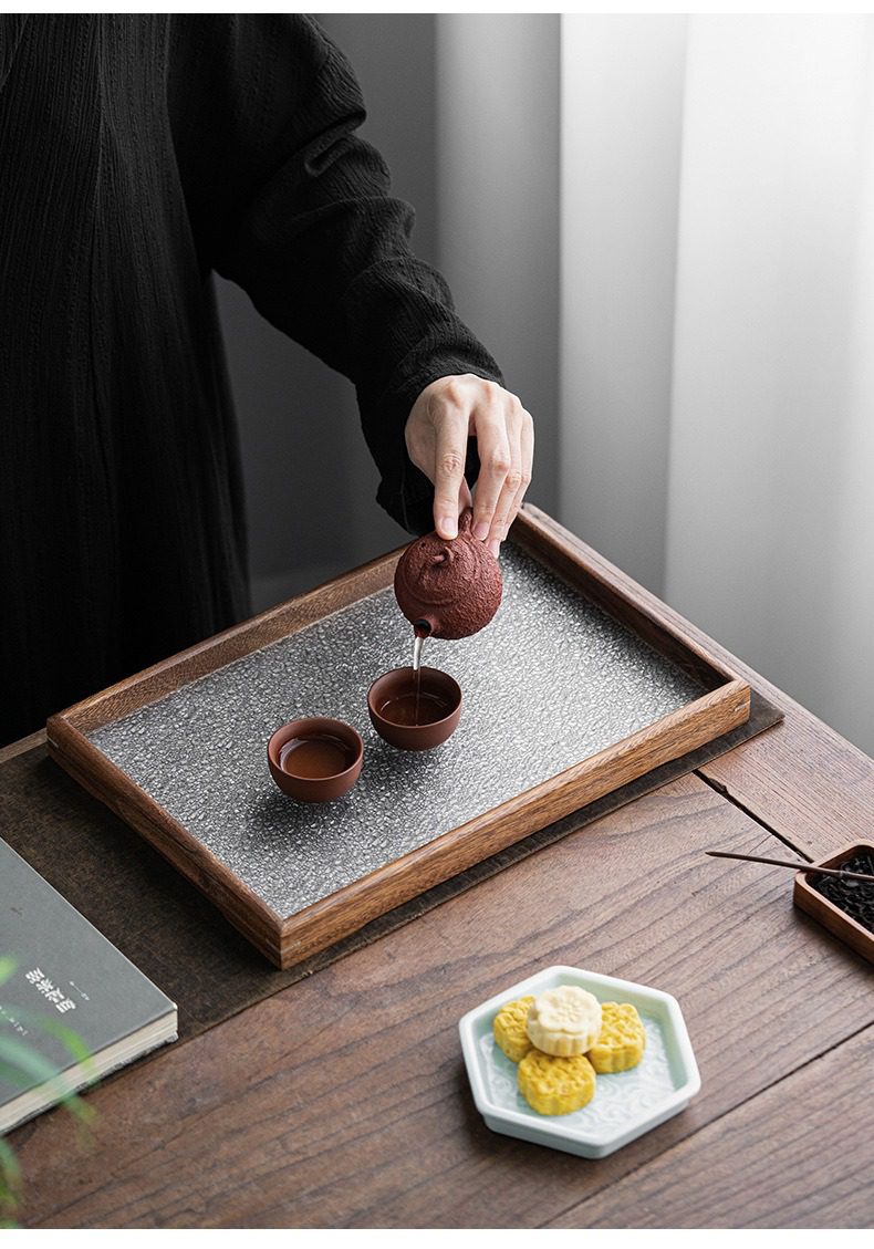 胡桃木托盤，南山居手工梨皮泥紫砂壺，壺面質感細膩古樸，正為精緻紫砂茶杯注入醇厚茶湯，呈現極致禪意茶席。