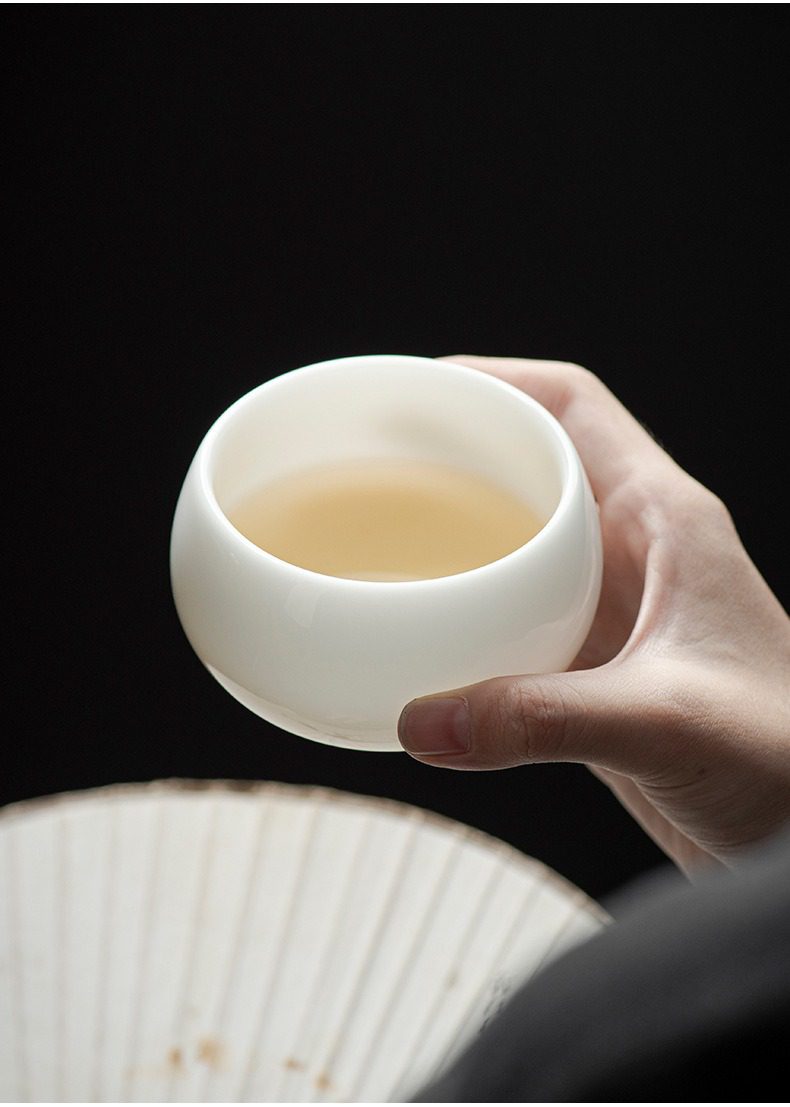白瓷羊脂玉羅漢品茗杯，南山居手工德化白瓷品茗杯，玉潤光滑的圓潤造型，盛裝著金黃茶湯，盡顯茶道之美。