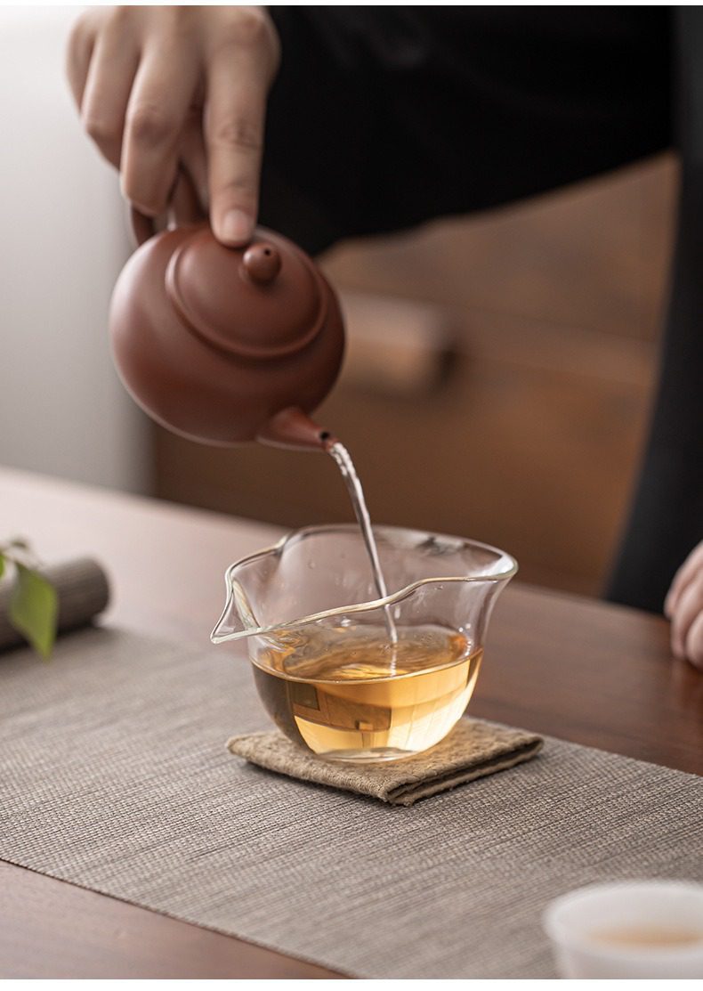 玻璃葫蘆公道杯，南山居手工朱泥圓潤紫砂壺，將金黃茶湯緩緩注入透明玻璃公道杯中，展現專業茶道。