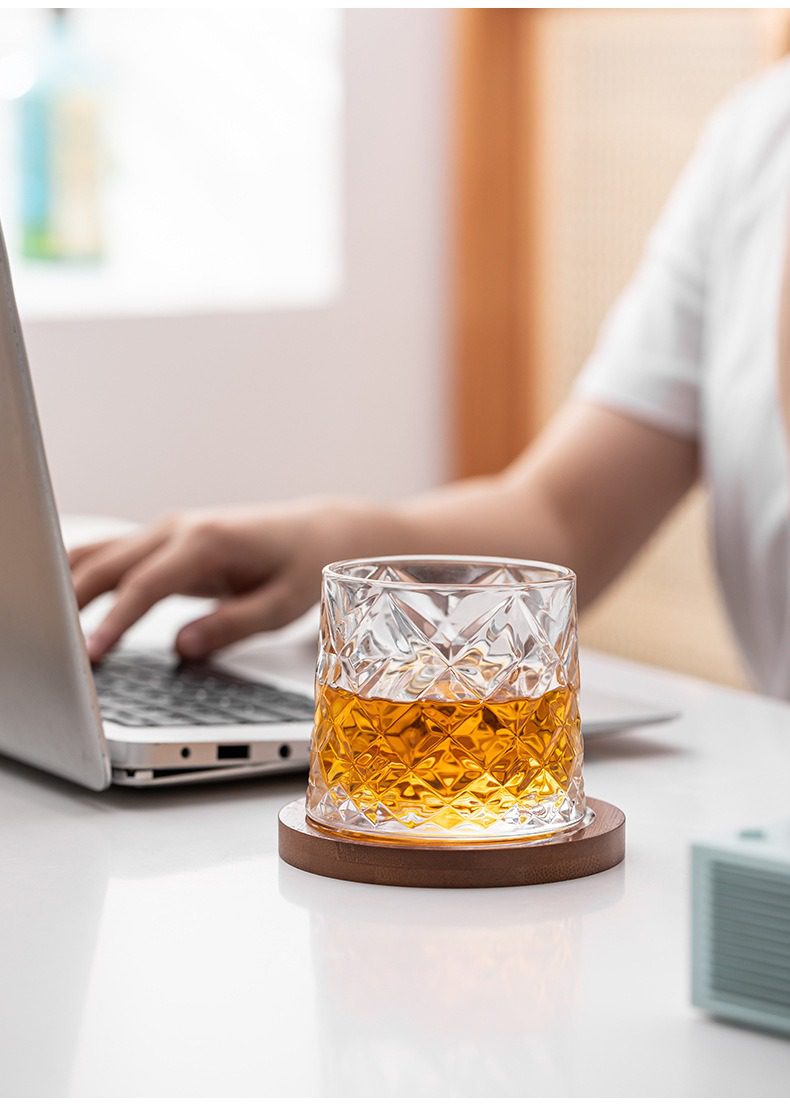 日式玻璃水杯，南山居鑽石紋玻璃杯，盛裝琥珀色茶湯，置於溫潤實木杯墊，展現現代品茗的雅緻風格。