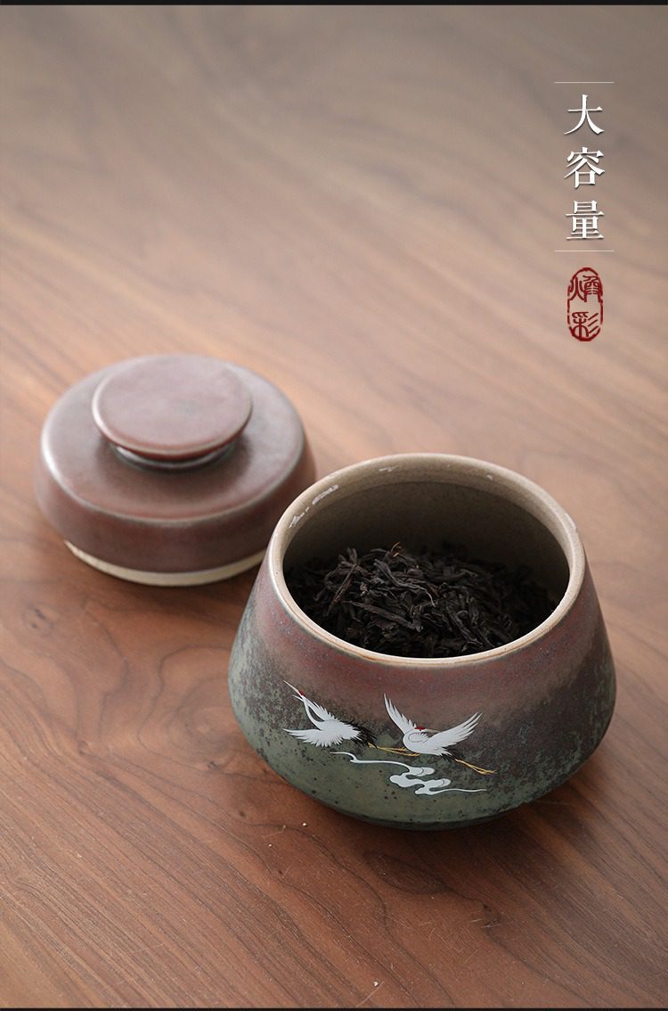 窯變煥彩瑞鶴呈祥茶葉罐，南山居大容量窯變釉鶴舞存茶罐，深紅漸變墨綠色，瓶身繪有優雅白鶴，內盛高品質茶葉。