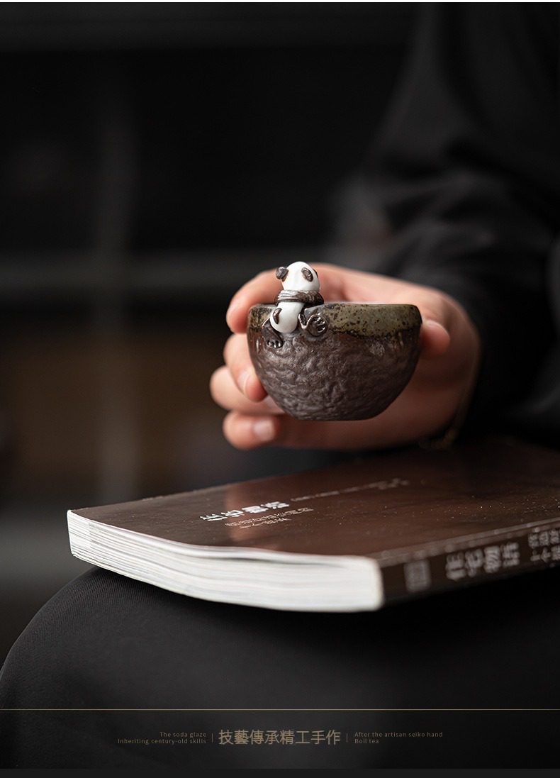 古早燒粗陶熊貓品茗杯，南山居手作粗陶茶碗，器身滿布自然紋理，碗緣點綴呆萌熊貓茶寵，獨具雅趣，為茶席增添生機。