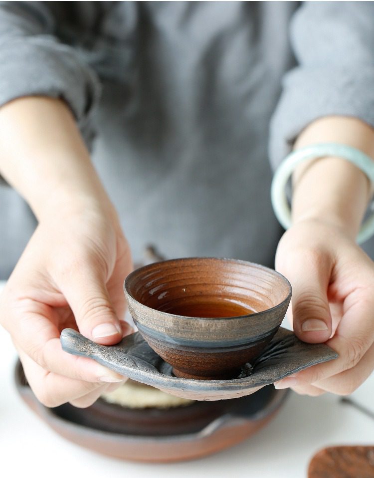 古早燒葉子杯墊，南山居手工陶藝茶杯與葉形茶托，杯身樸拙雅緻，盛裝茶湯色澤溫潤。