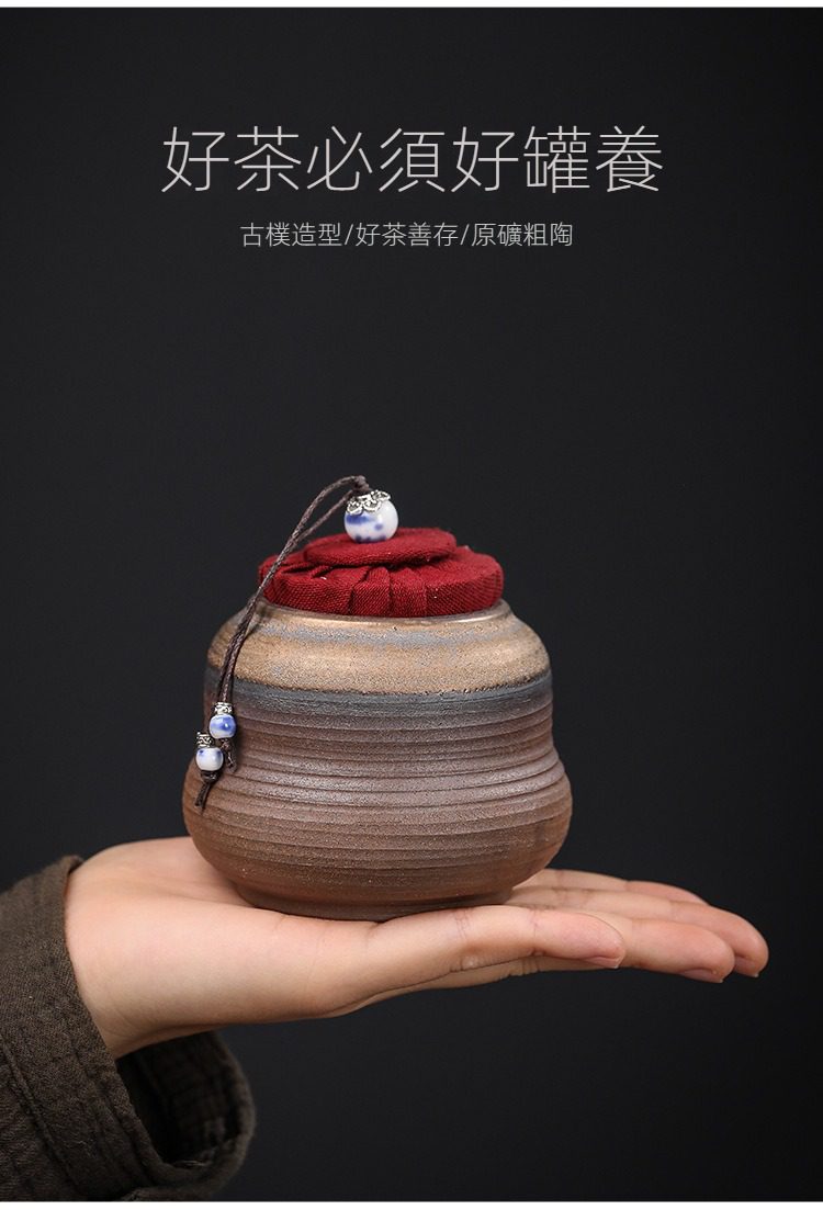 古早燒福祿茶葉罐，南山居原礦粗陶茶葉罐，古樸造型搭配紅色布藝蓋與青花珠飾，展現粗獷之美。