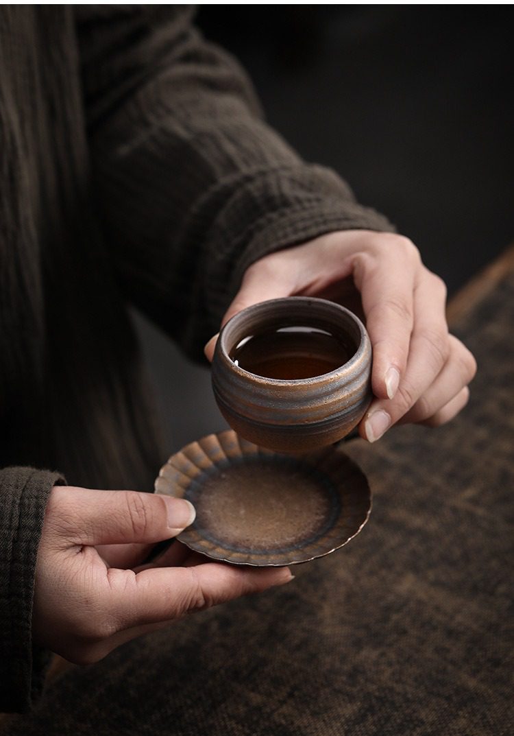古早燒品茗杯，南山居手工粗陶茶盞，器型圓潤，杯身帶有獨特環狀紋理，搭配波浪形茶碟，展現復古禪意美學。