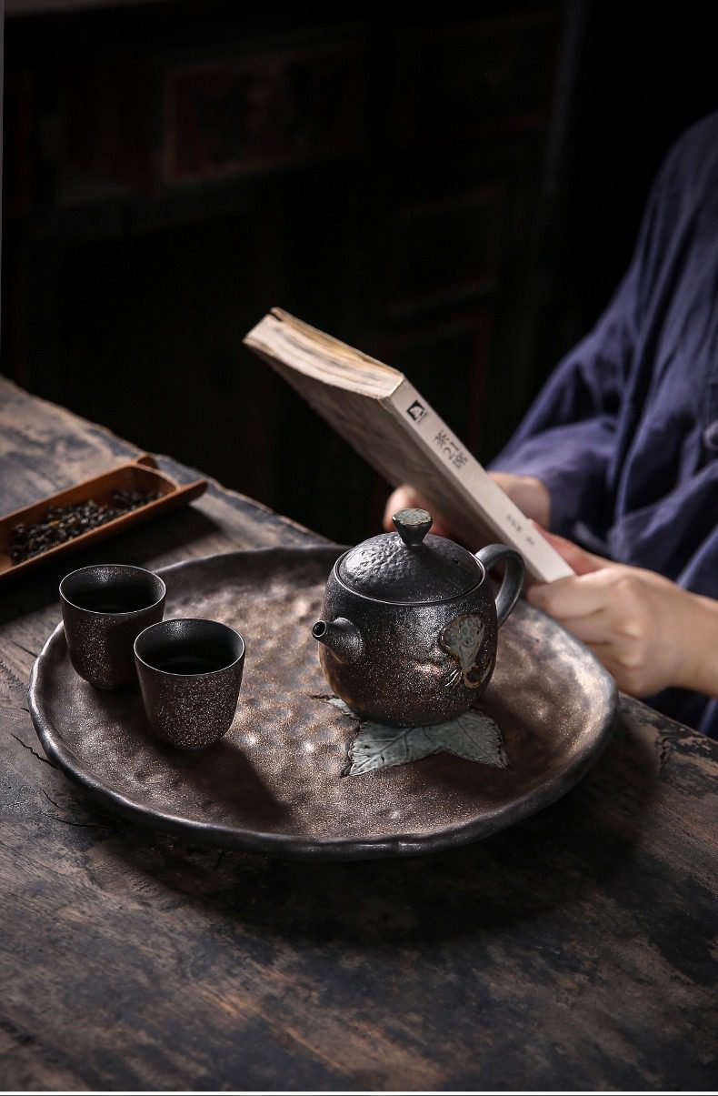 窯變青野蓮蓬茶壺，南山居手工粗陶茶具，包含獨特岩礦蓮花紋茶壺、兩只粗陶茶杯及仿石紋茶盤，呈現靜謐茶席氛圍。