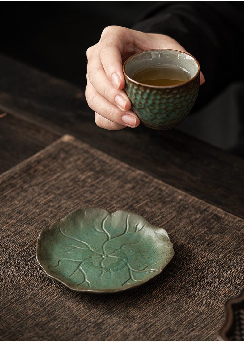 窯變青野杯墊，南山居手工青釉浮雕茶杯與荷葉茶托，茶湯清澈，展現禪意茶席美學。