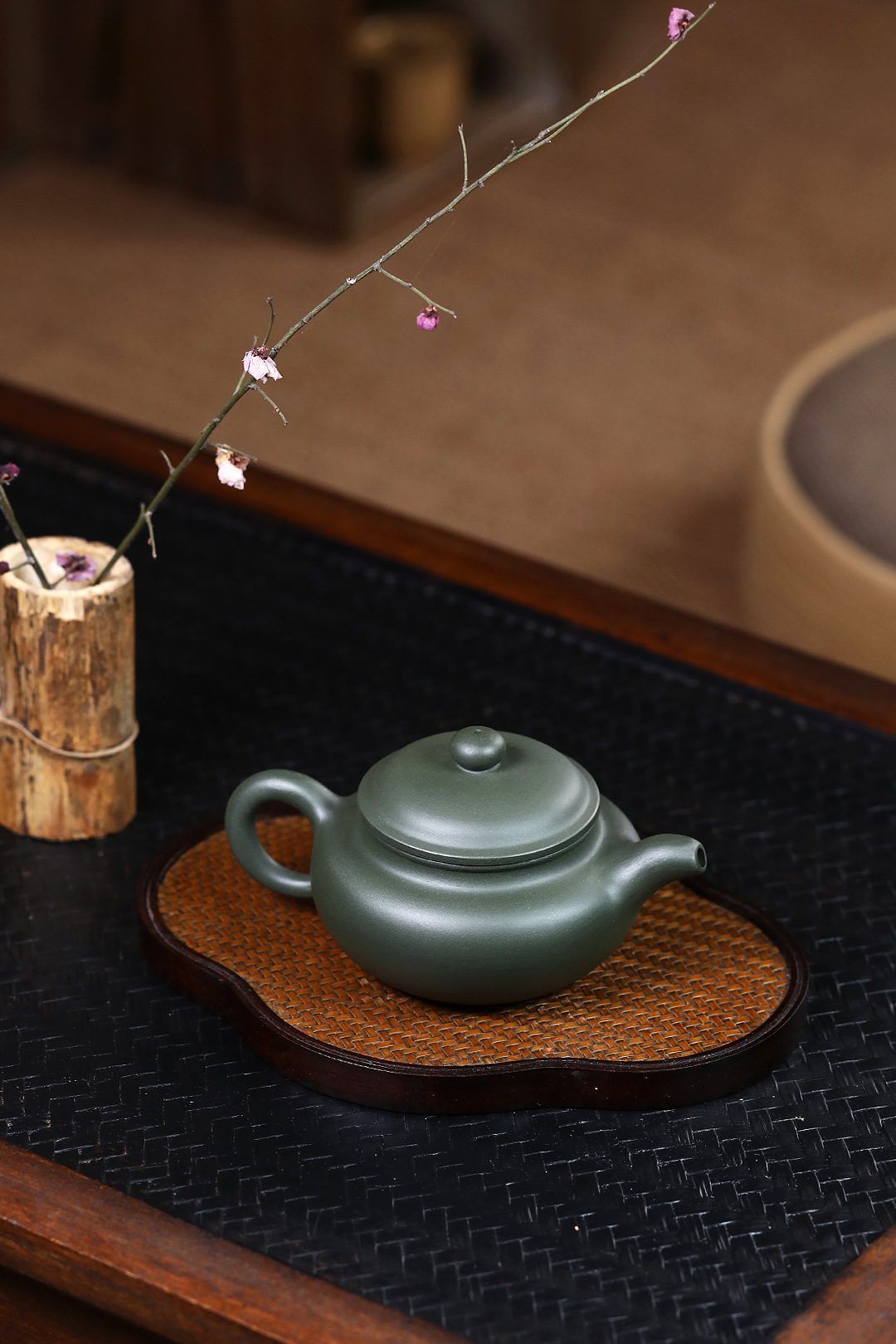 宜興紫砂壺原礦綠泥鳥趣仿古茶壺(250ml)，南山居墨綠色紫砂壺，壺身圓潤雅緻，色澤沉穩，置於竹編茶盤上，盡顯茶道禪意。