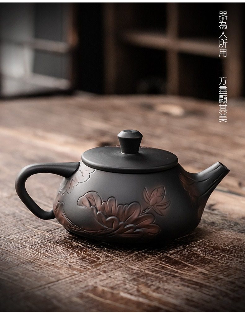 紫陶清溪蓮香茶壺，南山居精緻黑砂浮雕荷花紫砂壺，壺身古樸典雅，浮雕花紋層次分明，展現手工茶具魅力。
