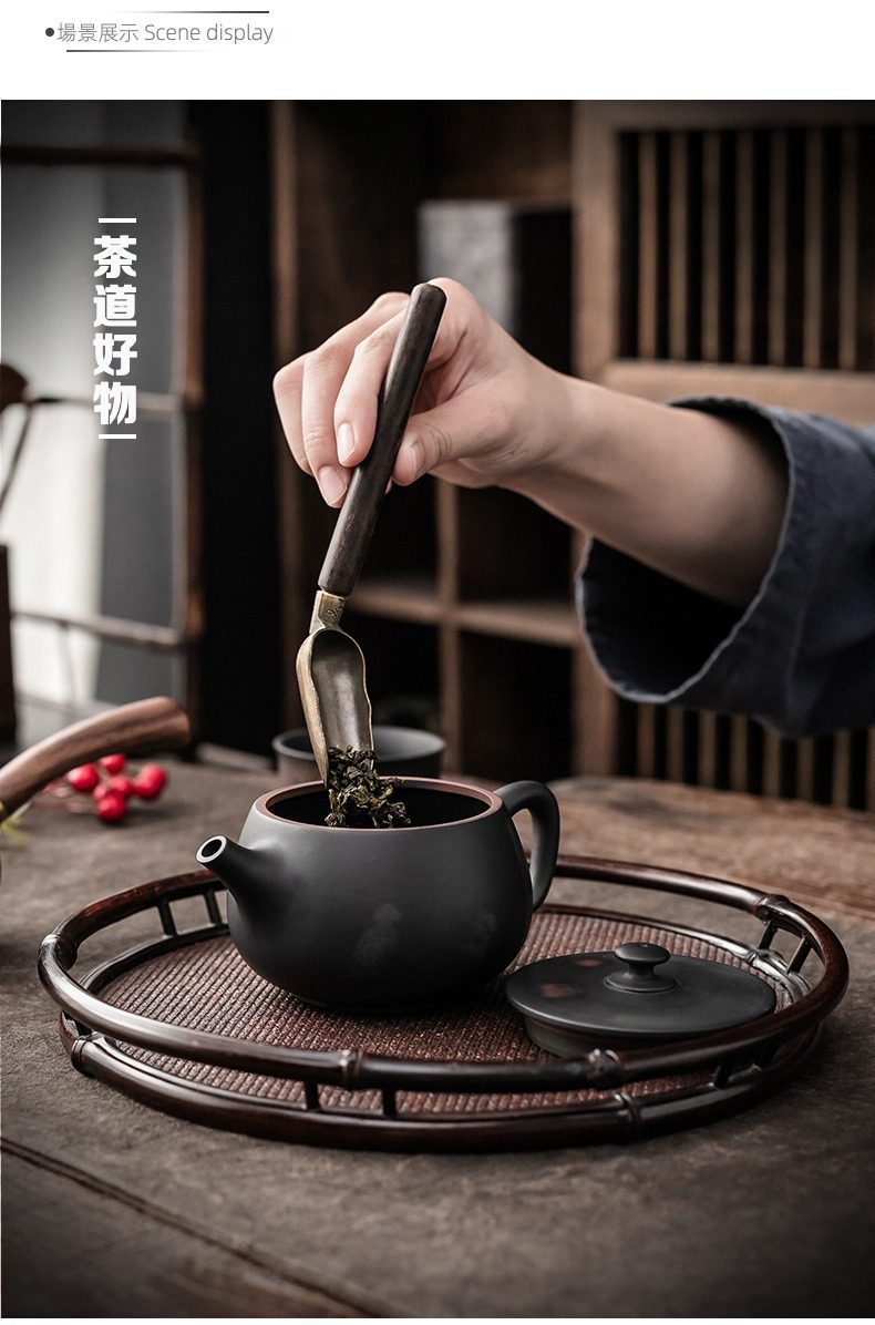 紫陶清溪荷韻茶壺，南山居木柄茶勺將散茶置入素雅紫砂壺，搭配圓形竹編茶盤，展現專業茶道美學。