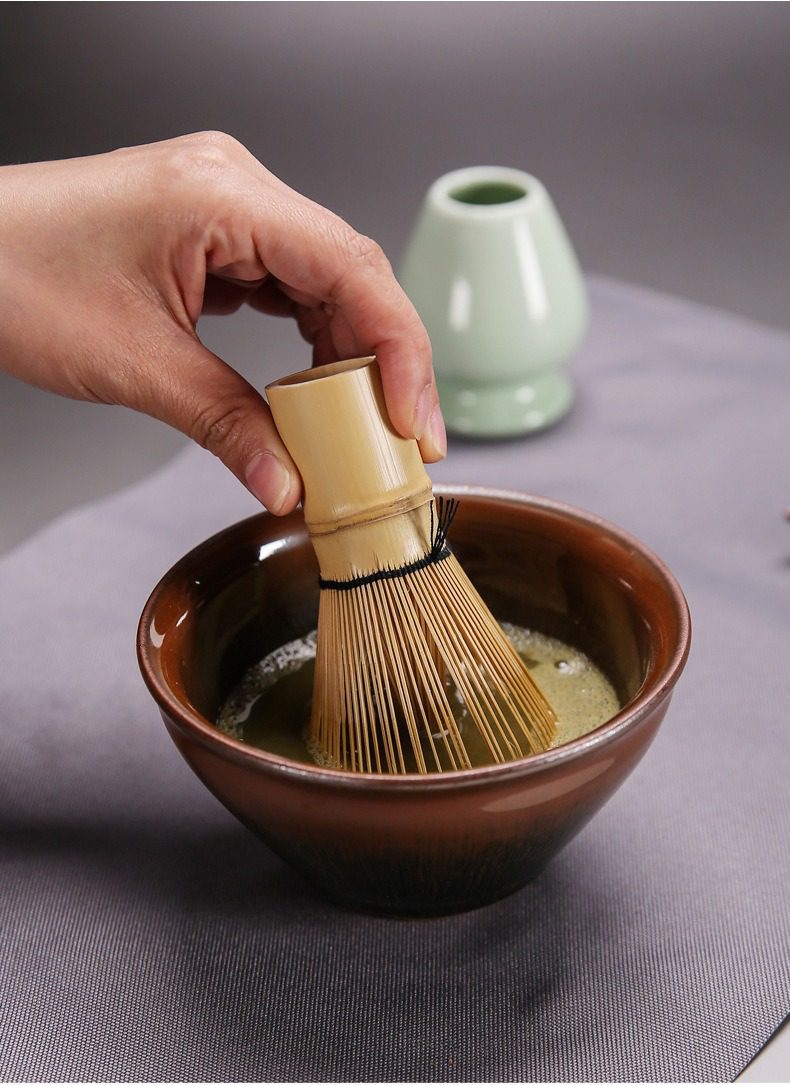 點茶精裝抹茶套組，南山居竹製茶筅輕拂翠綠抹茶，搭配溫潤陶瓷抹茶碗與青瓷茶筅座，呈現優雅抹茶茶道。