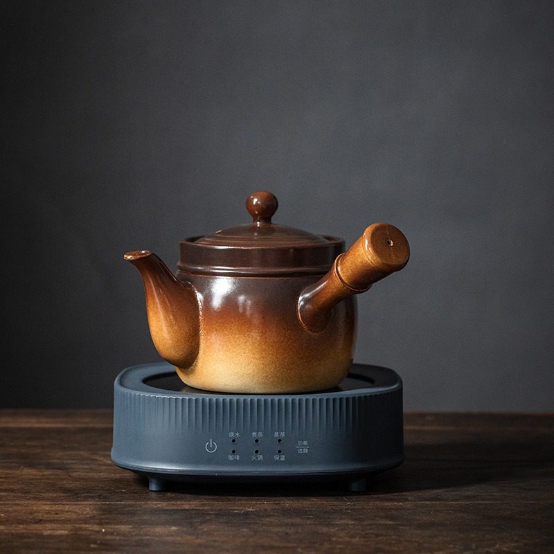 漸變炭火溫茶爐，南山居漸變陶製煮茶壺，配實木橫把，壺身圓潤，坐於智能電茶爐上，展現茶道美學。