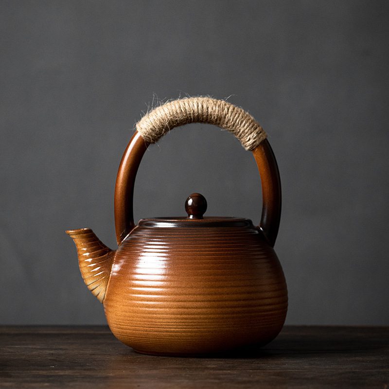 漸變炭火溫茶爐，南山居手工粗陶提樑壺，深棕漸層釉色壺身，麻繩纏繞陶瓷提把，展現質樸禪意茶具。