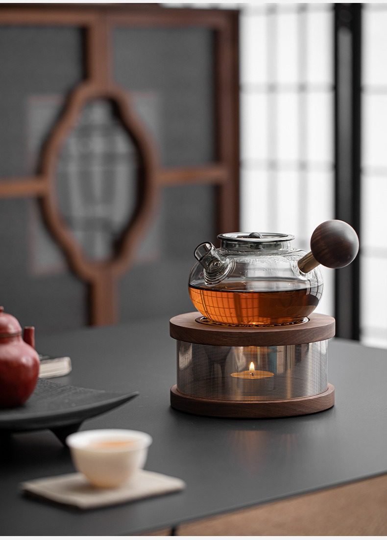 胡桃木溫茶爐，南山居玻璃溫茶壺組，包含圓潤耐熱玻璃茶壺與實木燭台溫茶器。壺中茶湯琥珀清澈，燭火溫暖。