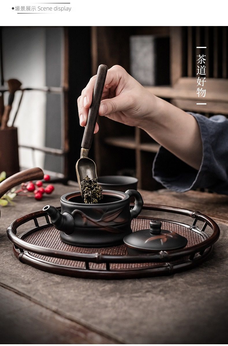 紫陶清溪竹韻茶壺，南山居黑泥雕花茶壺，手持木柄茶則將烏龍茶葉輕柔置入，展現茶道美學與沖泡儀式感。