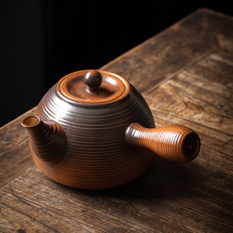 漸變炭火溫茶爐，南山居手工柴燒側把陶壺，壺身滿布古樸紋理，泥色溫潤深邃，出水順暢。