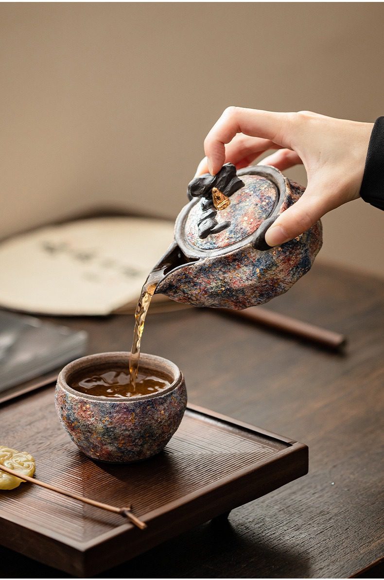 岩礦手抓壺，南山居手工柴燒茶壺與茶杯組，器身呈現斑斕星空釉色，樸拙質感結合金色點綴。